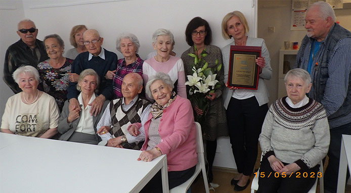 zdjęcie 4 Grupa seniorów z Dziennego Domu dla Osób Starszych z Wilanowa z kierownikiem i pracownikami dumnie prezentują otrzymany certfikat
